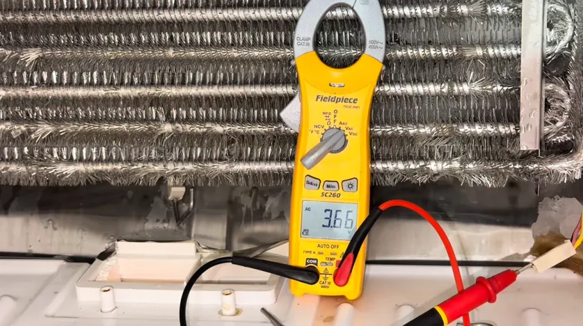 Clamp meter testing a refrigerator defrost heater during appliance repair