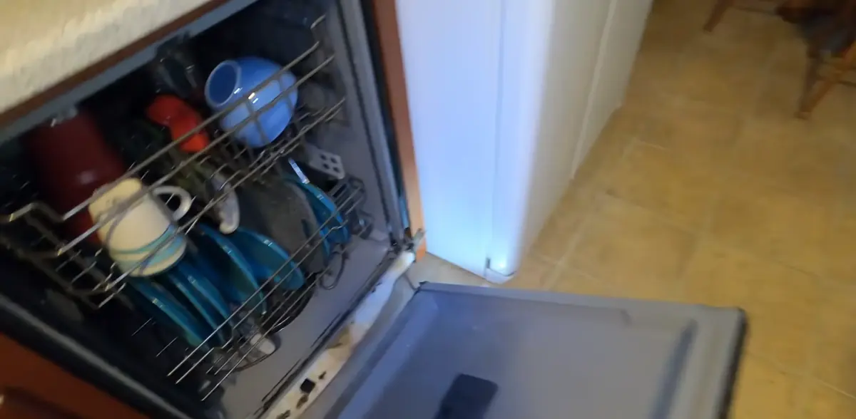 Open dishwasher racks with dishes that are not coming out clean