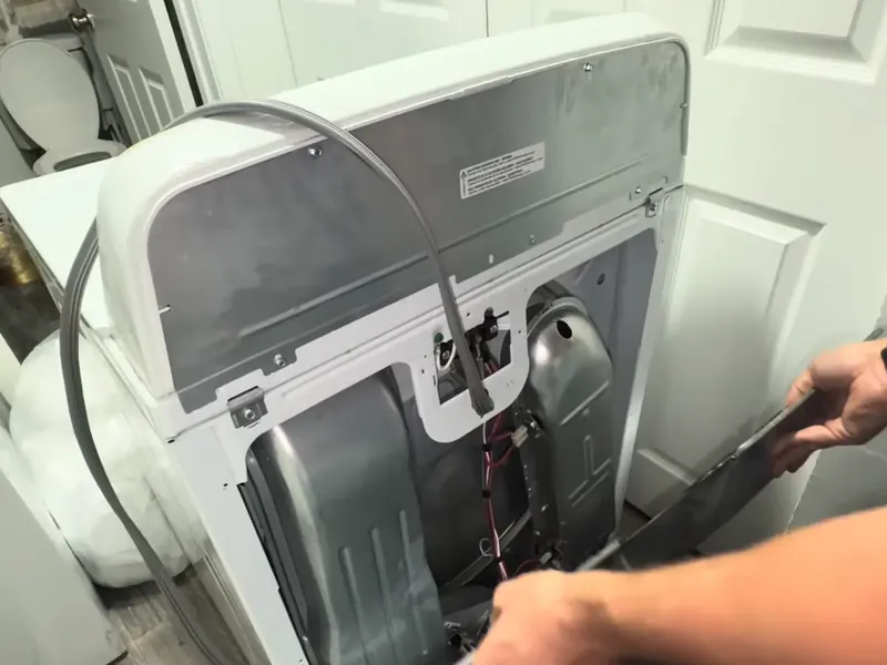 Technician working inside a dryer with the panel removed during dryer repair in Bradenton