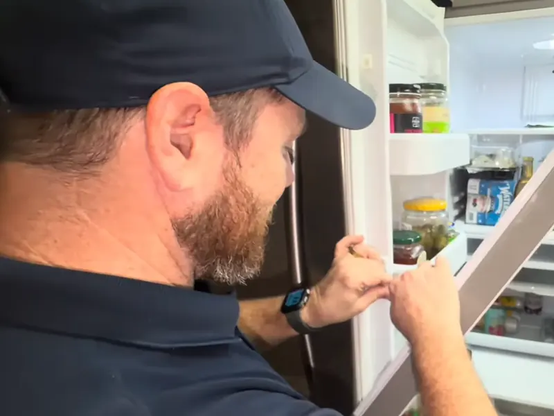 Technician replacing a refrigerator door gasket during refrigerator repair in Bradenton, FL