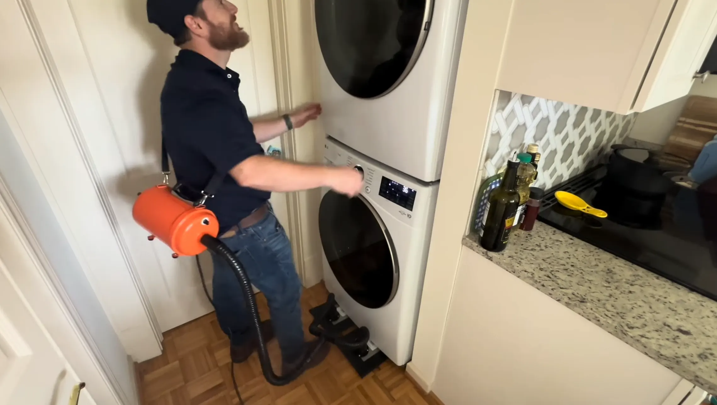 Technician clearing lint from a stacked washer and dryer vent