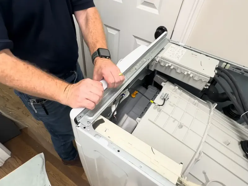 Technician lifting the top of a top load washer for washer repair in Bradenton